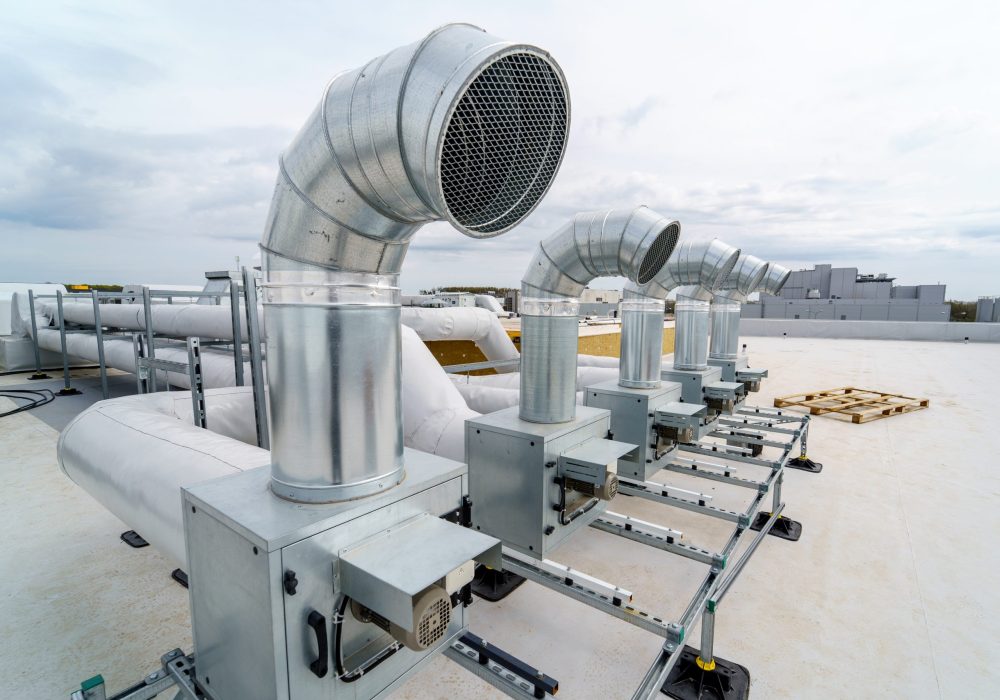 The air conditioning and ventilation system of a large industrial building is located on the roof. It consists of air ducts, air conditioning, smoke removal and ventilation